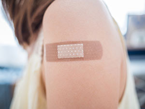 Student with bandage on arm after receiving vaccine
